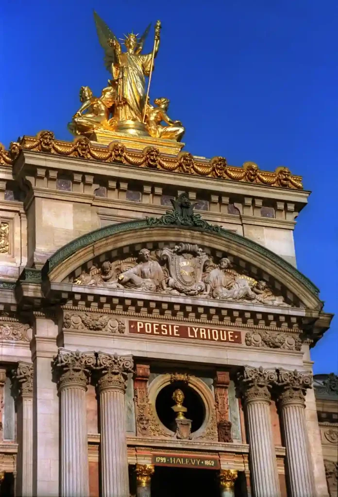 Historic façade of Palais Garnier in Paris with golden statue and lyrical poetry inscription