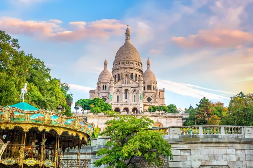 Sacre-Coeur Basilica in Montmartre, Paris with carousel and blue sky at sunset