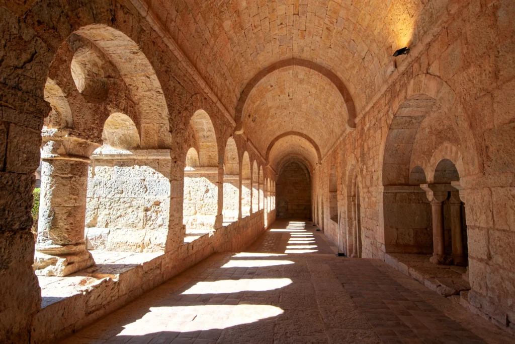 Sunlit arches of a historic French abbey in autumn