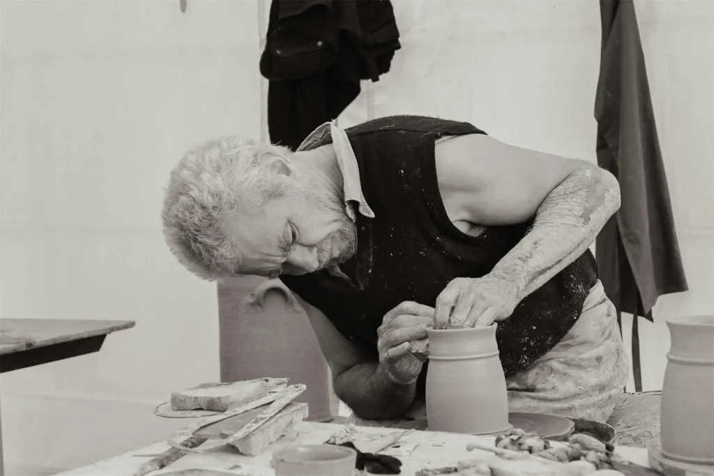Experienced ceramic artist crafting a handmade clay vase in a traditional French pottery studio