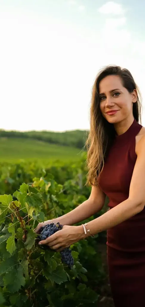 Woman in red dress walking through a vineyard at golden hour during tailor-made honeymoons in France