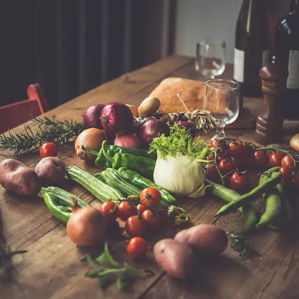 Organic vegetables and wine on a rustic wooden table in Provence