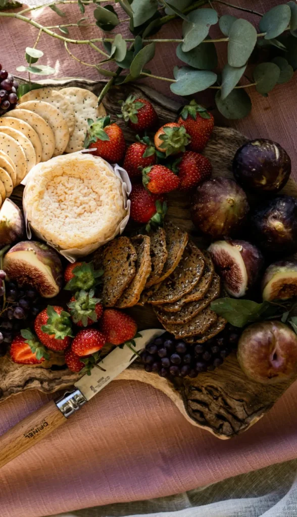 Luxury French cheese and fruit board with grapes, figs and artisan crackers