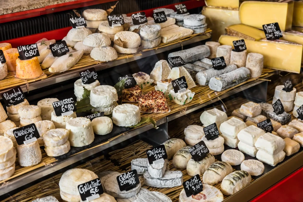 Artisanal cheeses displayed in a traditional French market