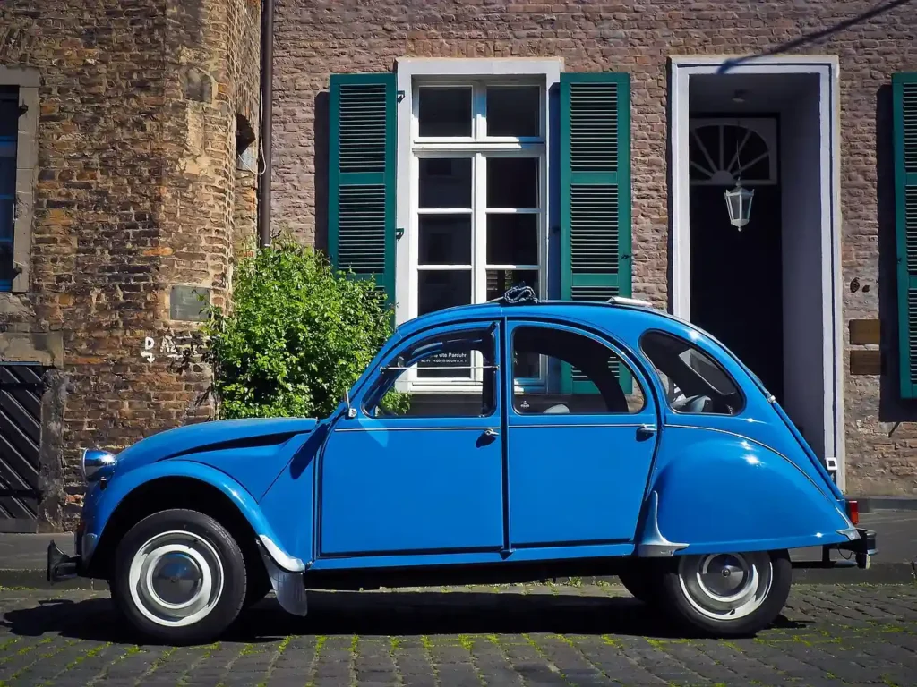 Vintage French car parked by a charming countryside home