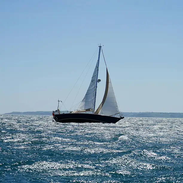 Elegant sailboat gliding through calm waters off the French coast