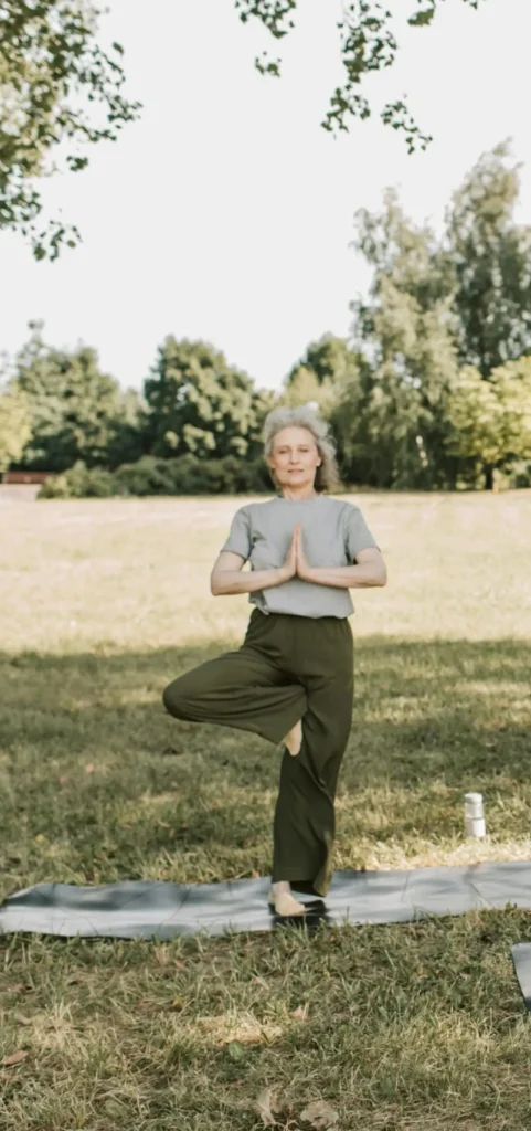 Woman meditating outdoors in a sunlit meadow in France