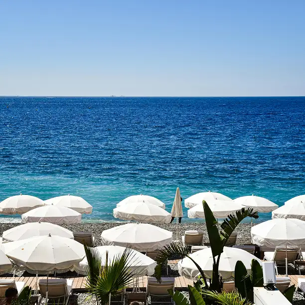 White sunbeds and parasols on a secluded private beach with calm waters