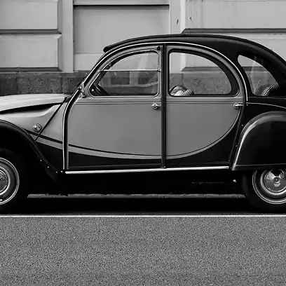 Vintage black car in front of stone wall