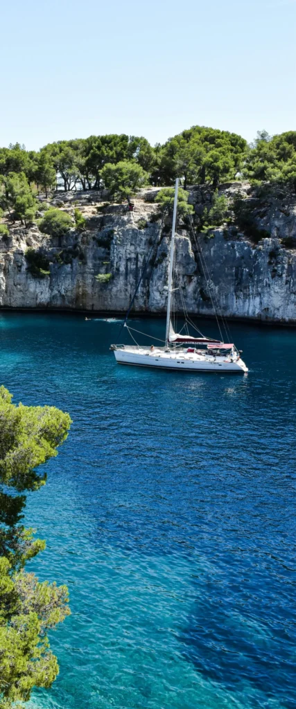 Sailboat anchored in a quiet turquoise cove along the French coast