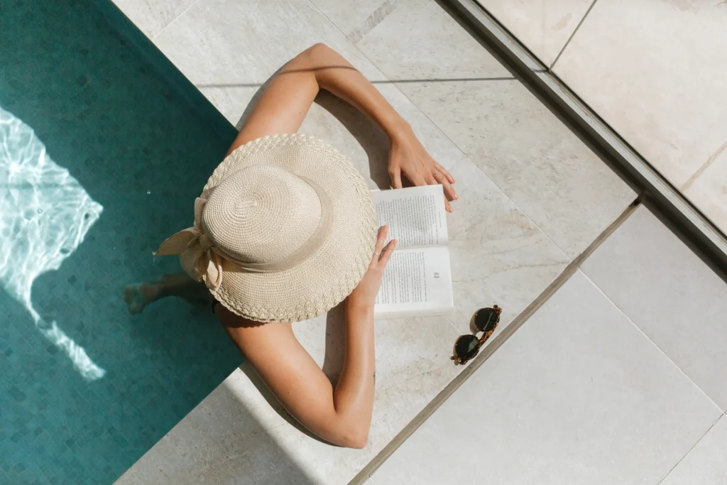 Woman reading by a private luxury pool in the South of France