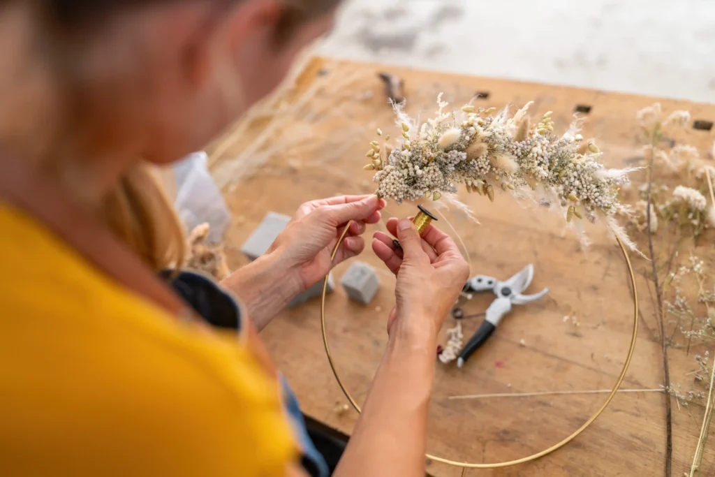 Close-up of hands arranging spring flowers during a creative workshop