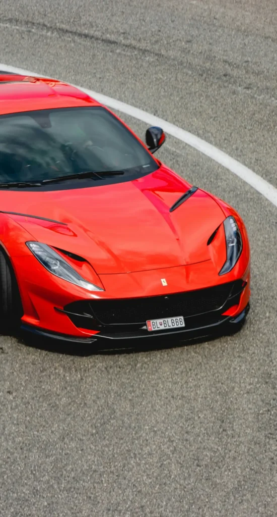 Red Ferrari driving on a scenic mountain road in France