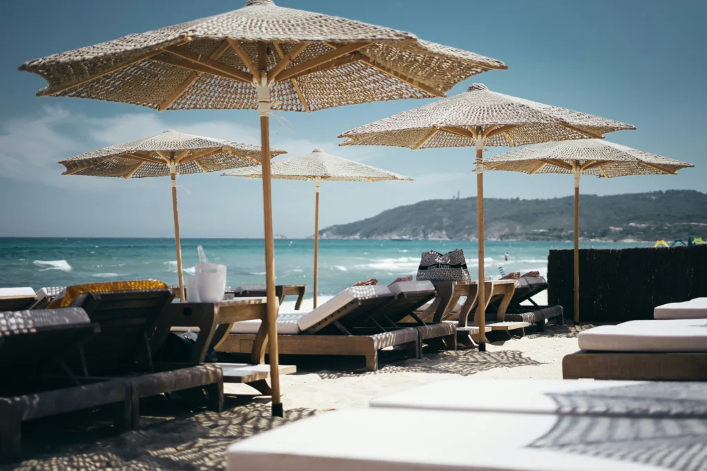 Chic sun loungers and straw parasols at a private beach club in Saint-Tropez