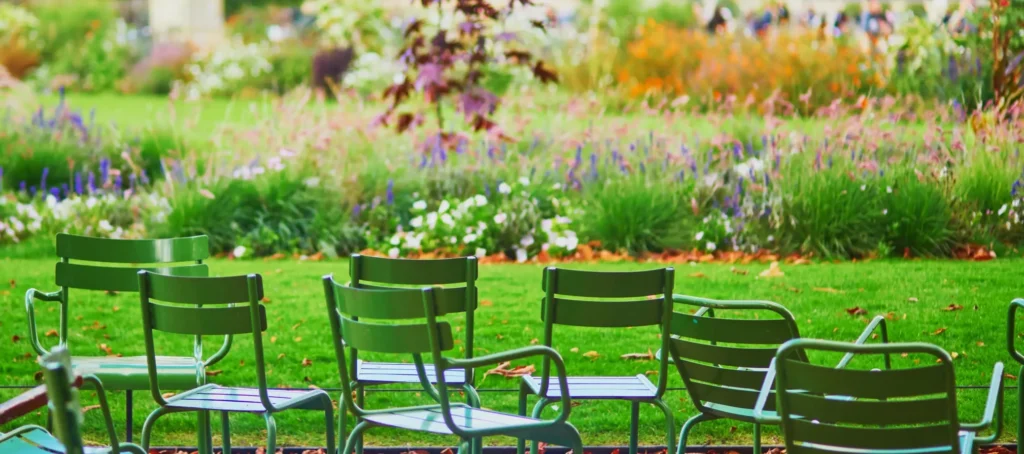 Chaises vertes au jardin des Tuileries avec le Louvre en arrière-plan, Paris en août