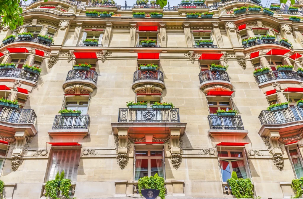 Avenue de Montaigne, Ornate Belle Époque building facade with red awnings and wrought-iron balconies in Monaco