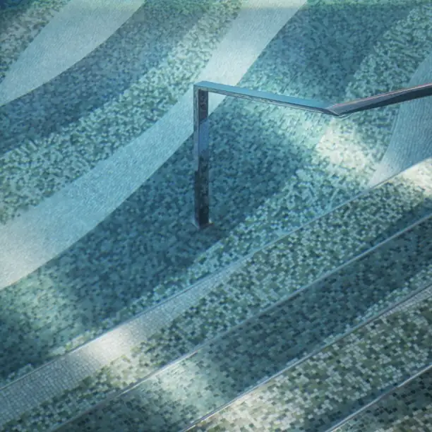 Elegant infinity pool with turquoise mosaic tiles and sunlight reflections at luxury French Riviera resort