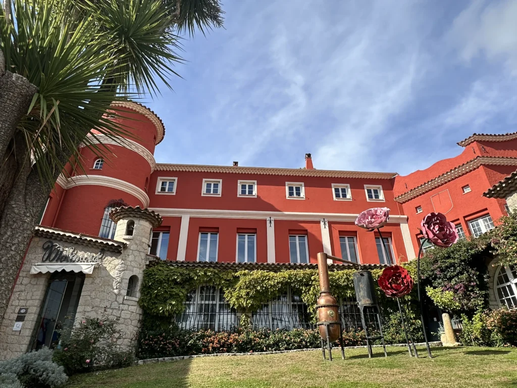 Élégante villa rouge avec jardins soignés et palmiers sur la Côte d'Azur