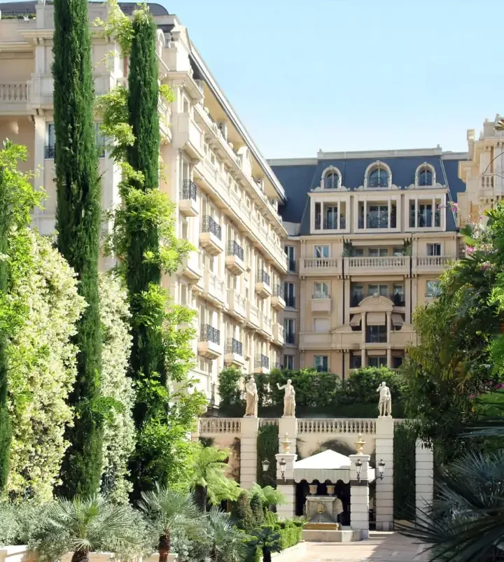 Elegant Belle Époque facade of luxury Monaco hotel with Mediterranean gardens and coastal views