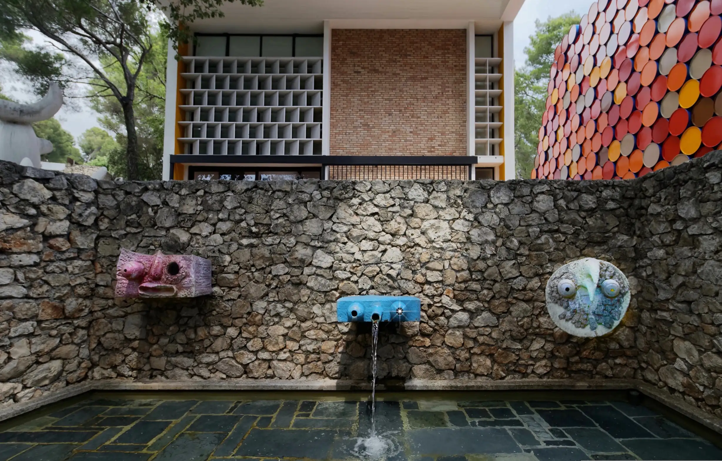 Classical stone fountain in formal garden with manicured cypress trees and Provençal landscape
