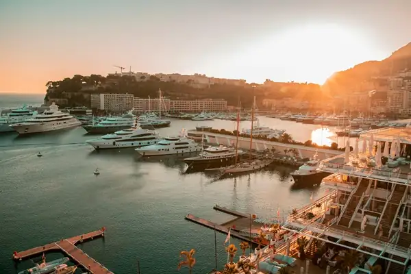 Golden sunset over French Riviera harbor with luxury yachts and coastal marina