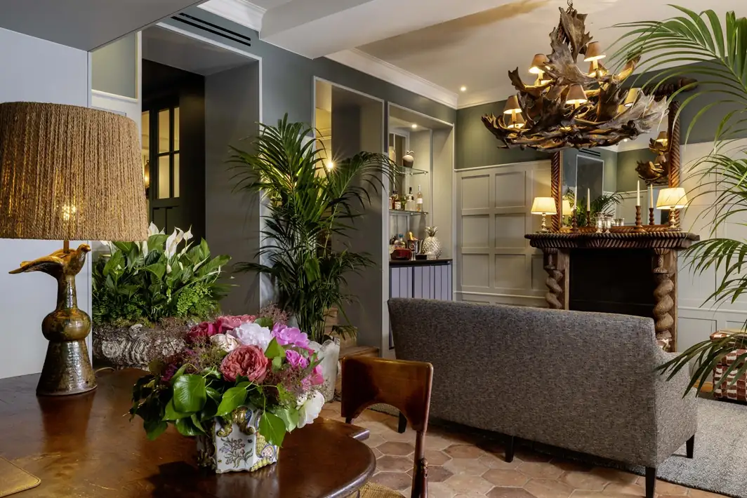 Luxurious hotel room at Hotel Aubepine Paris featuring botanical wallpaper, designer furniture, and elegant decor