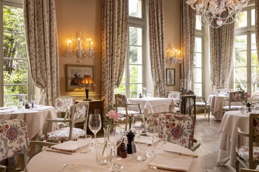 Opulent dining room at La Mirande Avignon with crystal chandelier and period furnishings