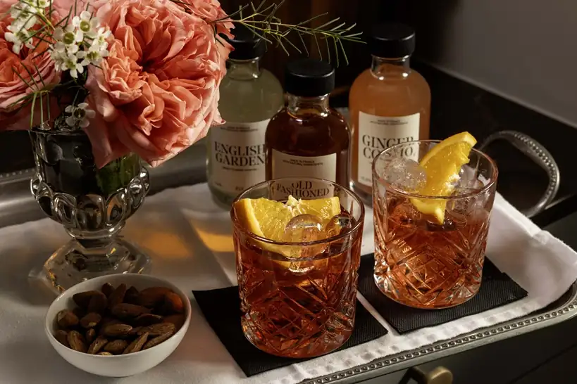 Artisanal cocktails with gourmet appetizers including olives, chocolate truffles, and premium spirits