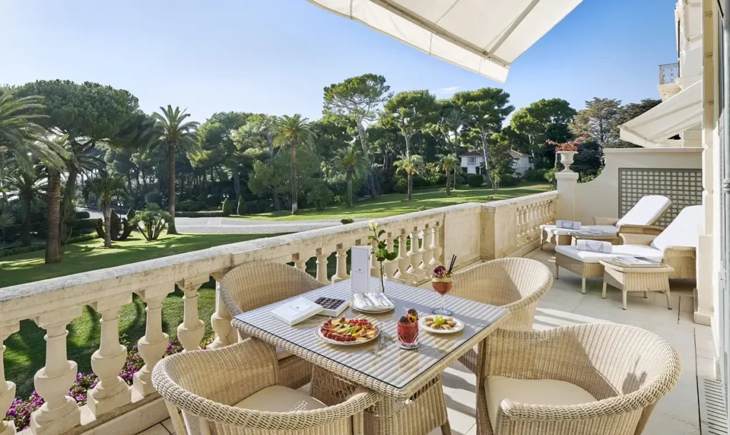 Exclusive hotel terrace with elegant table setting surrounded by lush Mediterranean gardens