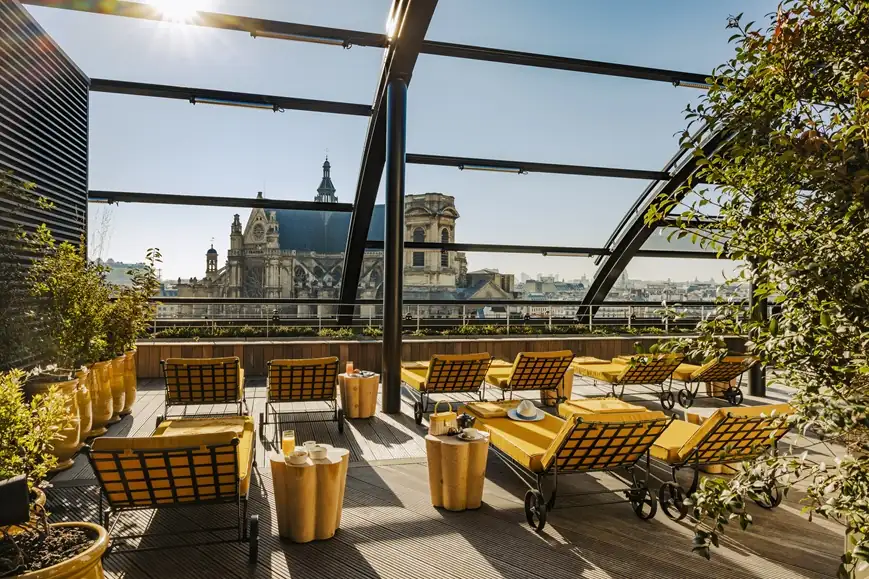 Rooftop solarium terrace at Hotel Madame Reve in Paris with lounge seating and city views.
