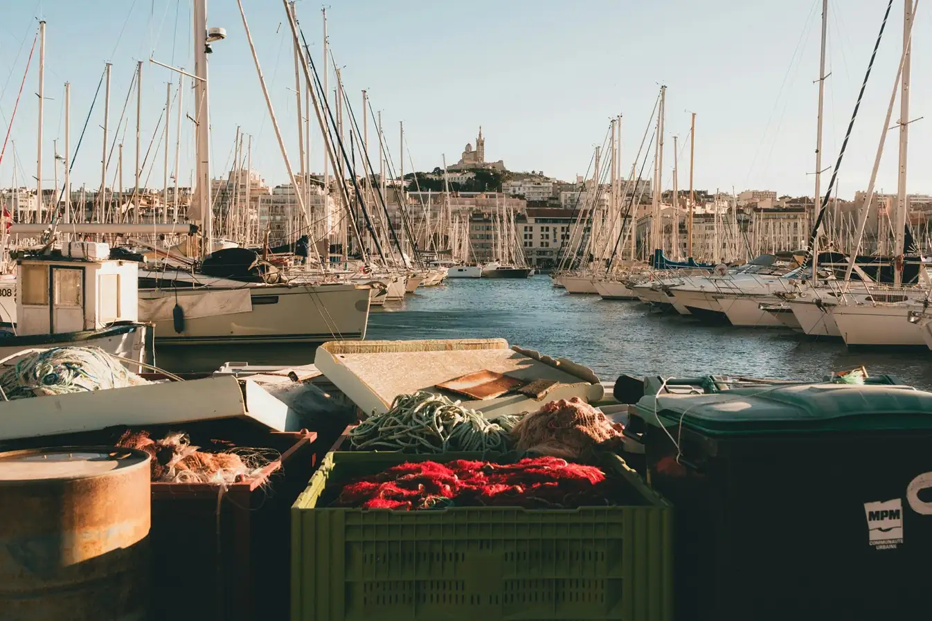 Scenic view of Marseille Old Port filled with sailboat masts and the Notre-Dame de la Garde basilica