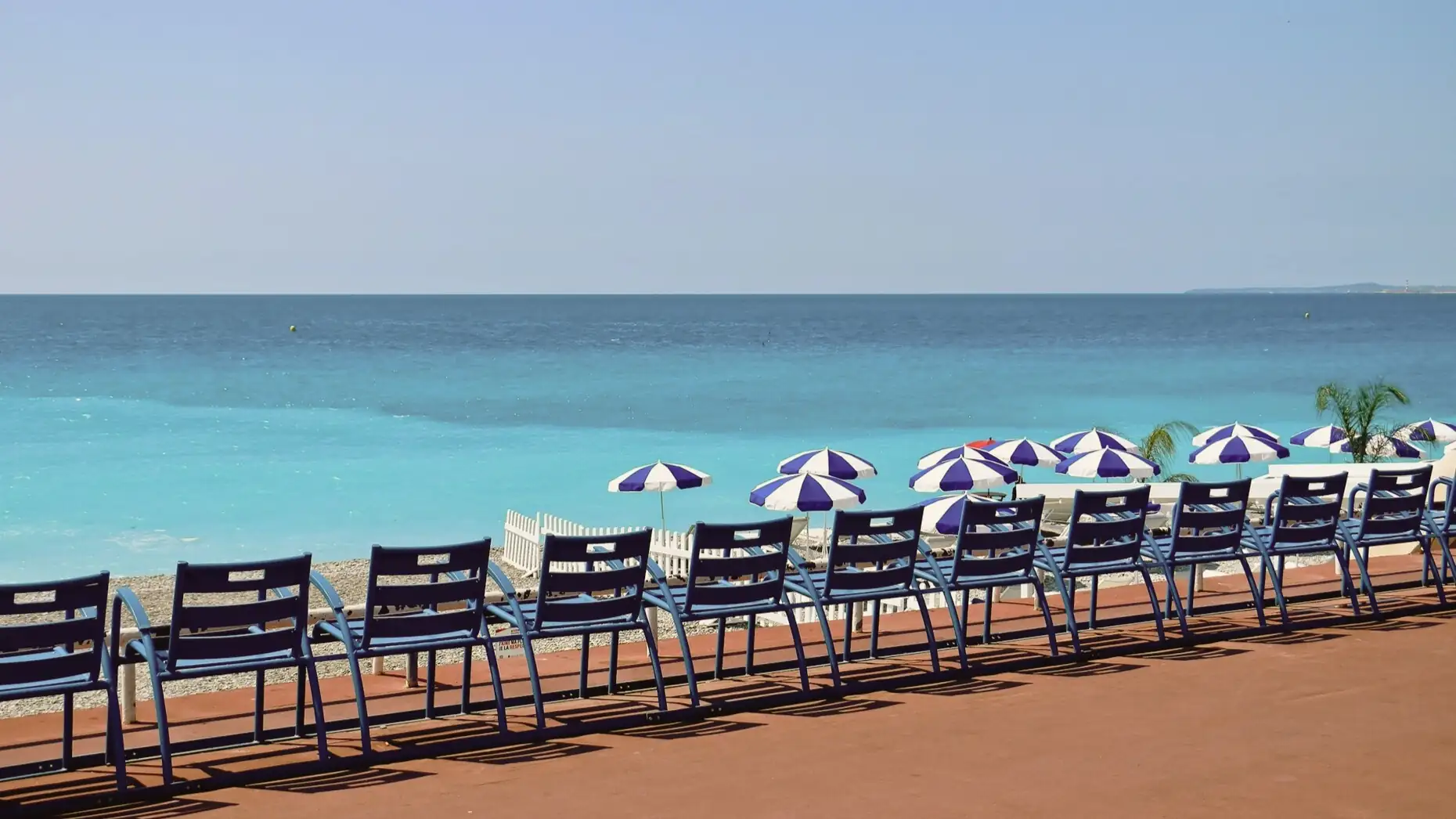 Iconic blue chairs facing the Mediterranean Sea on the Promenade des Anglais in Nice