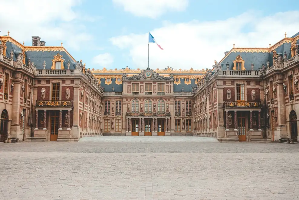 Grand historic palace courtyard in Paris with national flags and classical architecture.[memory:2]