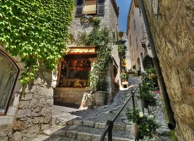 Charming stone stairway and narrow medieval lane with ivy-covered walls in Saint-Paul-de-Vence, France.