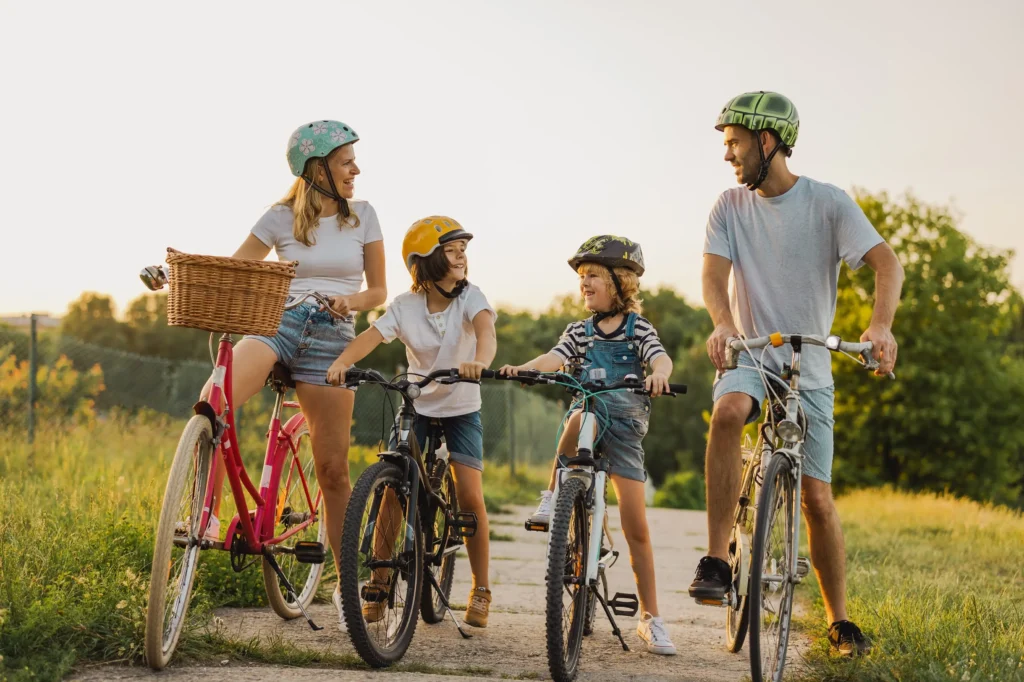 Happy family with children riding bikes through a sunny meadow in Provence