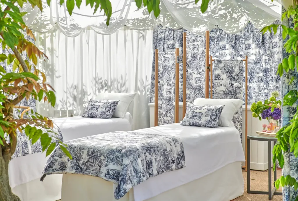 High-end outdoor spa treatment area with massage beds and white floral decor.