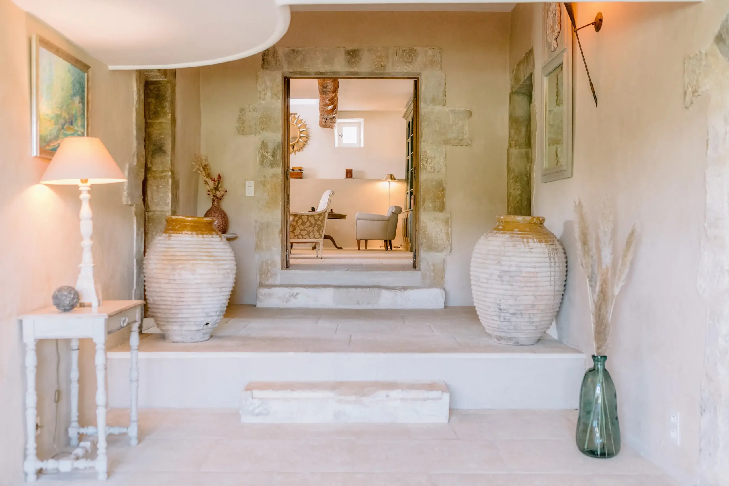 Minimalist luxury villa entrance in Provence with large terracotta jars and limestone walls