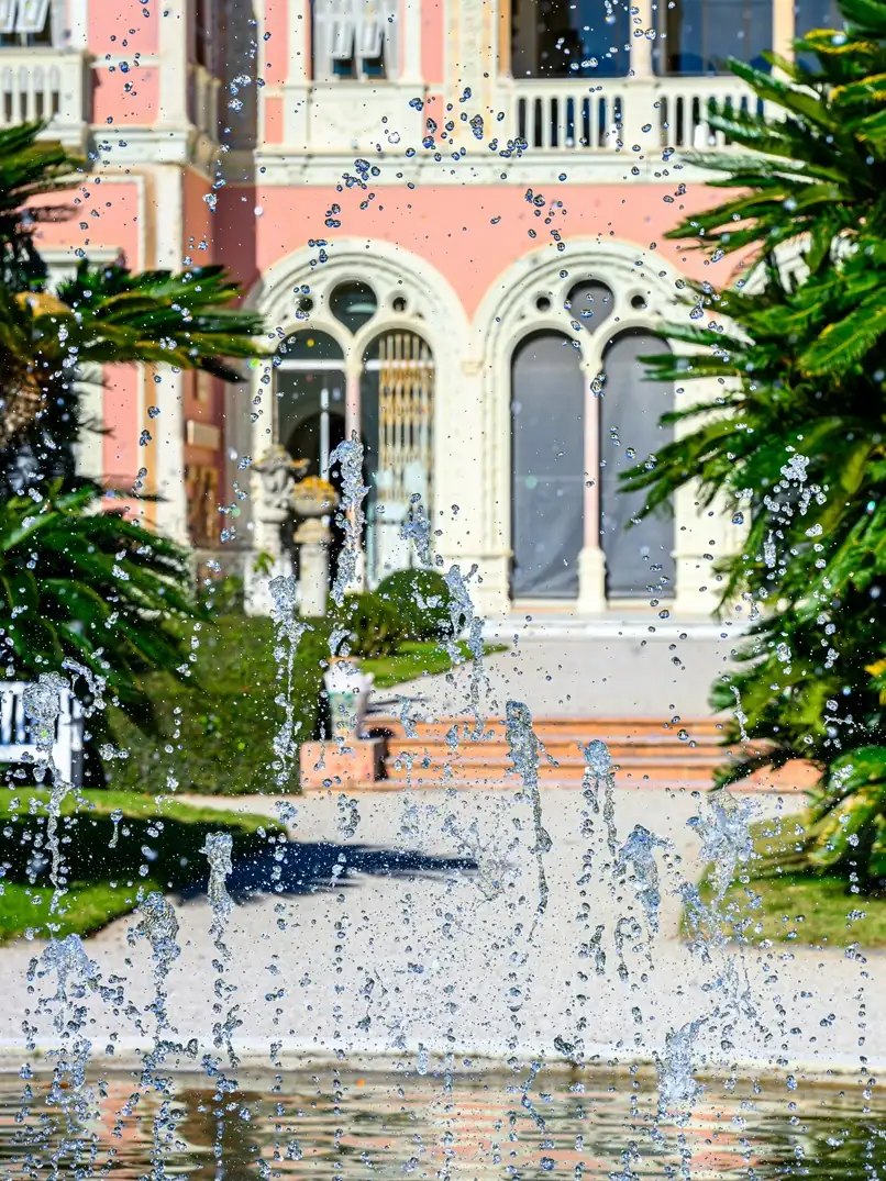 Ornate pink mansion with decorative fountain and elaborate Renaissance-style architectural details