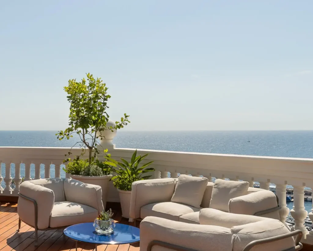 Spacious sunlit private terrace with elegant lounge furniture overlooking the Mediterranean Sea