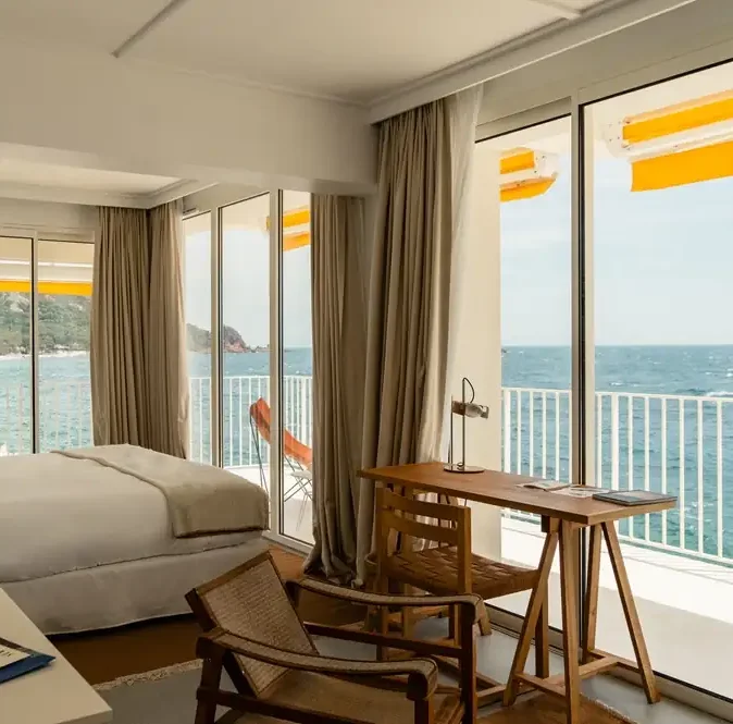 Modern seaside bedroom with panoramic coastal view at Hôtel Les Roches Rouges in Saint-Raphaël