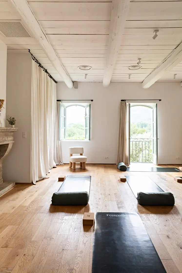 Bright minimalist yoga studio with wooden floors and natural light in a Provence bastide
