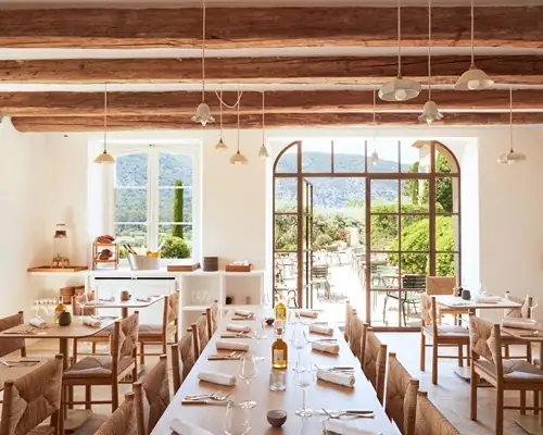 Light-filled communal dining room with long farmhouse table at a Provence wellness retreat