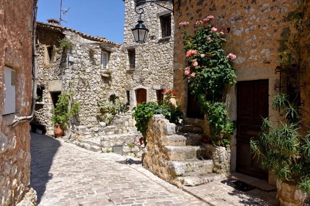 Flower-lined stone street in a historic French Riviera hilltop village
