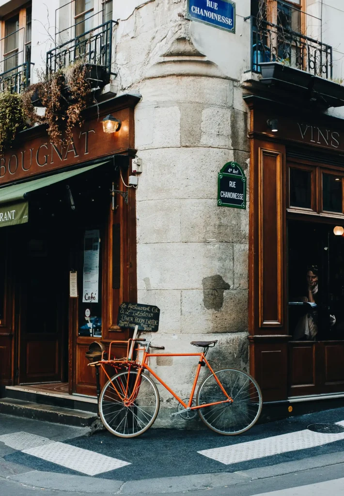 Classic Parisian café corner with a vintage bicycle parked on a cobblestone street